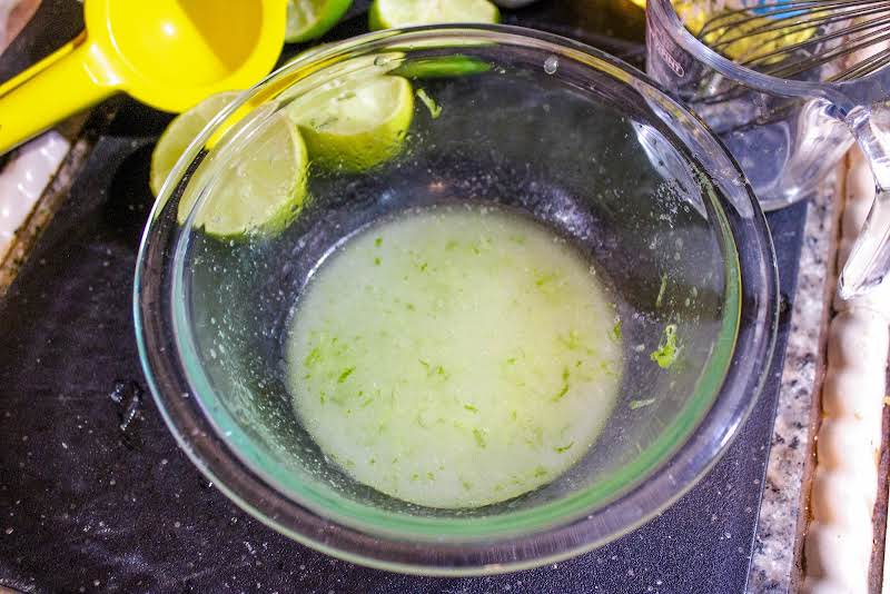 Lime Zest And Juice, Sugar, Salt, And Oil For The Dressing In A Bowl.