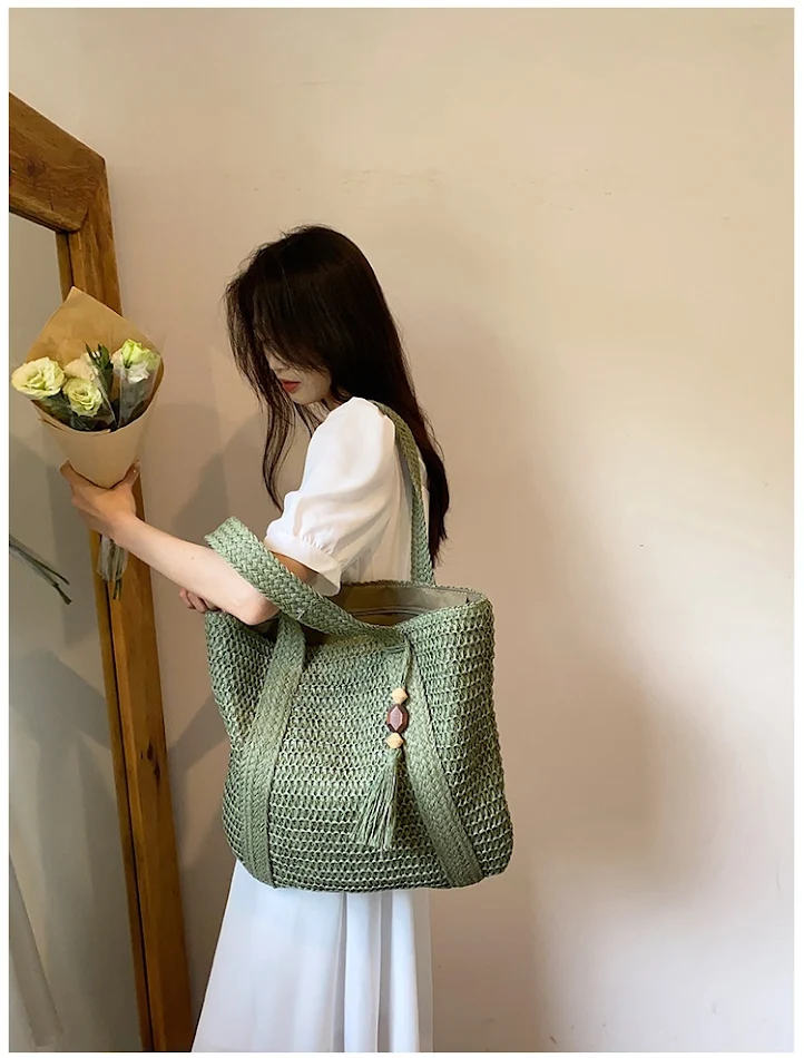 Bolsa feminina casual de praia com alça de ombro, palha e pingente de mogno, perfeita para um look fashion e leve.
