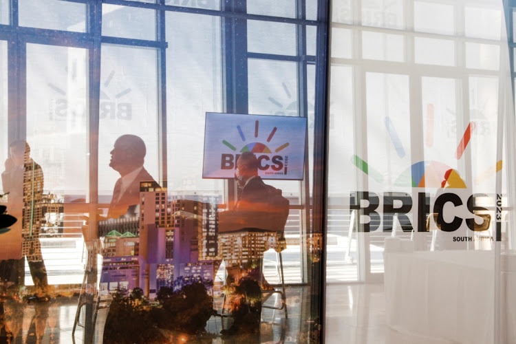 Delegates walk past the logos of the Brics summit in Johannesburg. Picture: GIANLUIGI GUERCIA/REUTERS