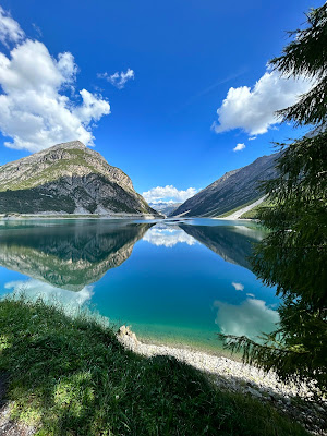 "Echi di Maestosità: Riflessi Montani in una Giornata Solare"