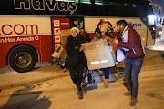 Hope SA Foundation founder Namritha Sivsanker and a Turkish interpreter carry a box of donations tp leave it at an operational building in the city of Adıyaman in the early hours of Friday morning, February 17, 2023
