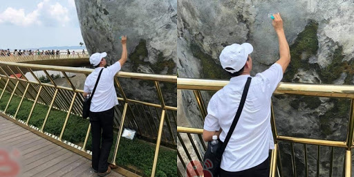 Người đàn ông thản nhiên dùng bút xóa ghi lên bàn tay khổng lồ.