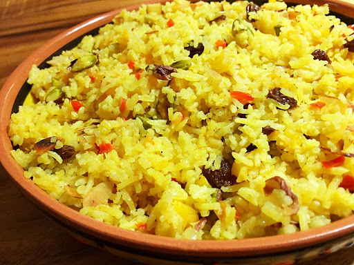 A bowl of rice with fruits.