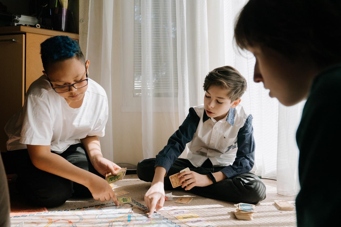 Kids playing a board game on the floor