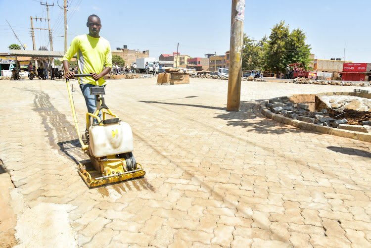 A worker levels cabros installed in Mwea town.