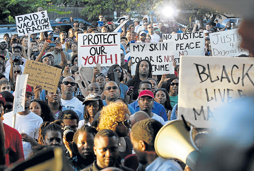 WANTING JUSTICE: Protesters listen during a rally against what demonstrators call police brutality in McKinney, Texas on Monday. Hundreds marched through the Dallas-area city of McKinney calling for the firing of police officer Eric Casebolt, seen in a video throwing a bikini-clad teenage girl to the ground and pointing his pistol at other youths at a pool party disturbance Picture: REUTERS