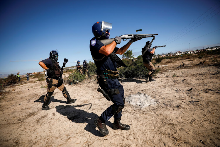 Police fire shotguns and teargas as they attempt to disperse Khayelitsha township residents trying to erect shacks on open ground during a nationwide lockdown aimed at limiting the spread of the coronavirus disease (COVID-19), in Cape Town, South Africa April 21, 2020. REUTERS/Mike Hutchings TPX IMAGES OF THE DAY