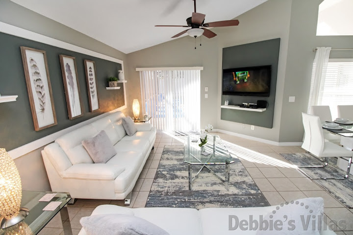 Wall-mounted flatscreen TV and doors to the pool deck in the lounge