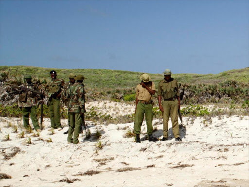 Kenya police officers patrol along the beach at Kiwayu Safari Village resort, Lamu. Photo/File