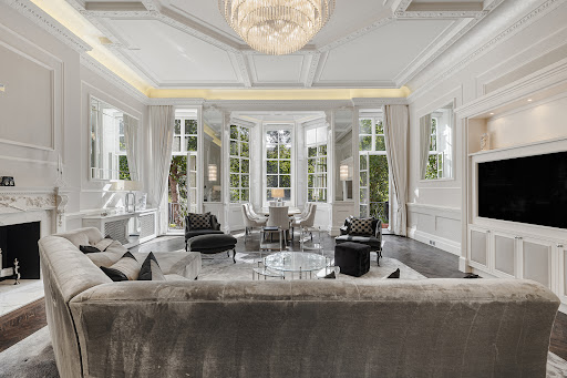 Luxury living room with fireplace and large window in this luxury property for sale in London ($9,320,483)