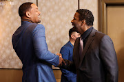 Actors Will Smith and Denzel Washington greet at the 94th Oscars Nominees Luncheon in Los Angeles.
