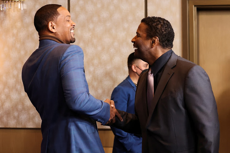 Actors Will Smith and Denzel Washington greet at the 94th Oscars Nominees Luncheon in Los Angeles.