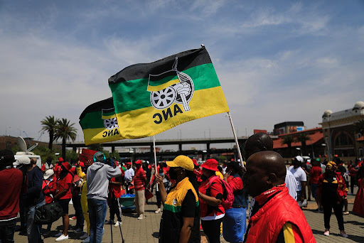Members affiliated to SA's largest trade union federation, Cosatu, raise the ANC flag as they gather in Newtown, Johannesburg on Thursday, October 7 2021, as part of a nationwide stay away. Cosatu said it is protesting against corruption, retrenchments and increasing job losses in SA.
