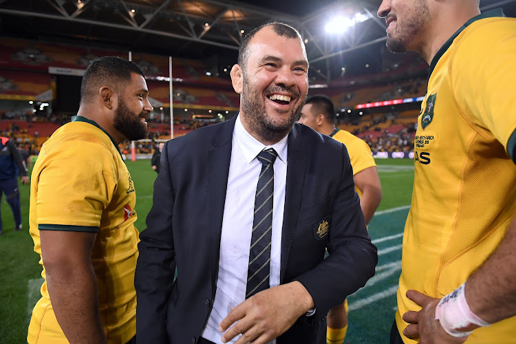 Australia's coach Michael Cheika celebrates with players after their Rugby Championship win over South Africa at Lang Park in Brisbane, Australia, on September 8, 2018.