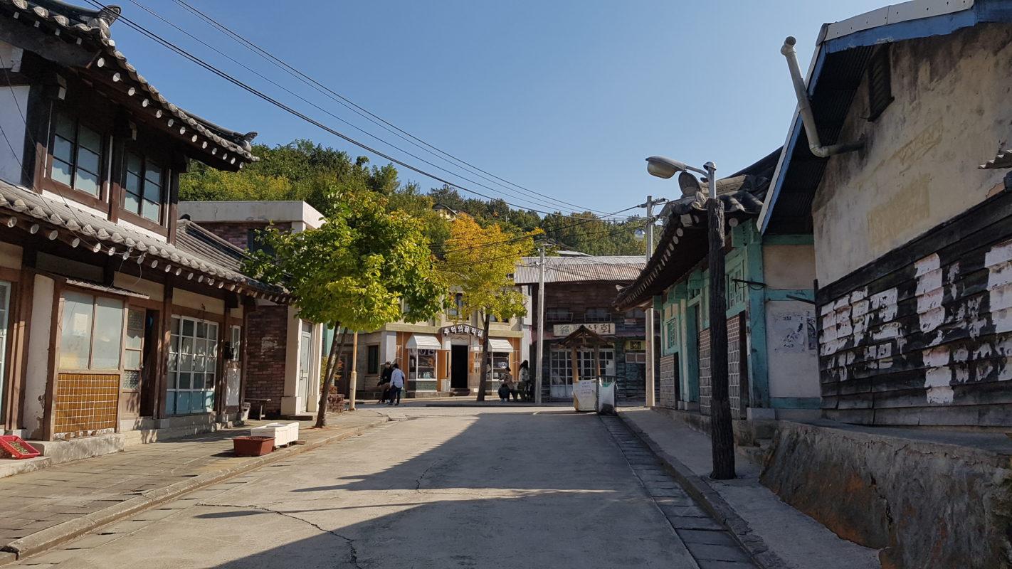 A close up of a street in front of a brick building

Description automatically generated