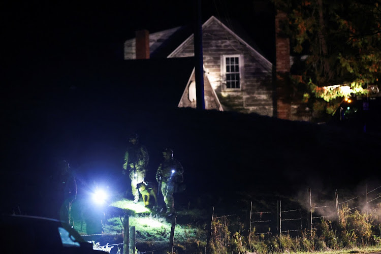 Law enforcement personnel surround a house in Bowdoin as they search for the suspect in the mass shootings in Lewiston, Maine, US, on October 26 2023. Picture: SHANNON STAPLETON/REUTERS