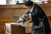 A resident receives humanitarian supplies on April 20, 2022 in Bucha, Ukraine. Some 1,500 Bucha residents received World Food Program supplies distributed at a Baptist Church during the last week.  