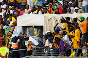 Police protect Kaizer Chiefs coach Arthur Zwane from fans during the DStv Premiership match between SuperSport United and Kaizer Chiefs at Royal Bafokeng Stadium on May 13, 2023 in Rustenburg, South Africa.   