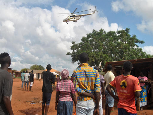 Residents look at a police helicopter patrolling near the closed house, where Italian volunteer for the Italian charity Africa Milele lived before she was seized, in Chakama trading centre of Magarini, Kilifi County, Kenya November 21, 2018. REUTERS/Stringer