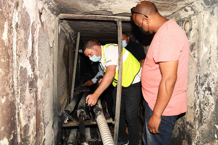 Cape Town mayor Geordin Hill-Lewis inspects some of the damage caused to power cables. Power was restored to all parts of the city on Tuesday evening.