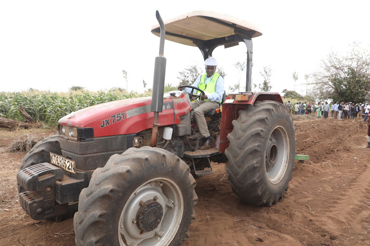Principal Secretary in the state department of Crops development Kello Harsma drives a tractor to launch the deep tillage farming technology at Chala in Taita Taveta County on September 2