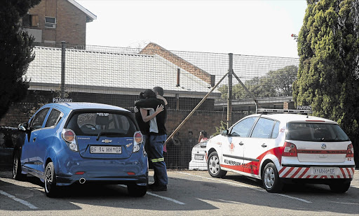 Two people who witnessed the fatal shooting at Moot police station in Pretoria comfort each other yesterday Picture: PEGGY NKOMO