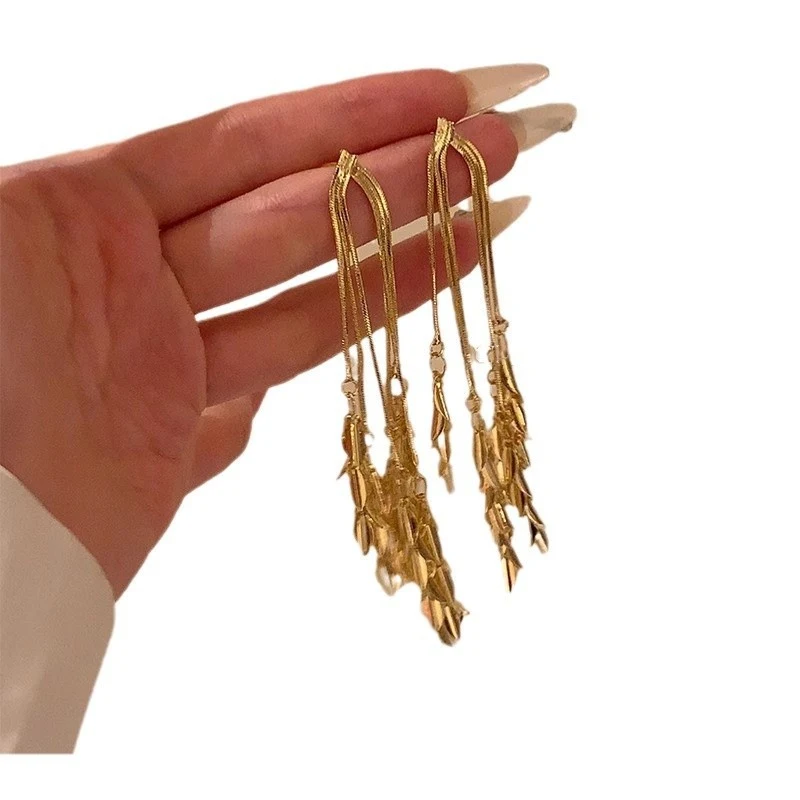 Gold Grandeur vrouwelijke oorstekers met kwastjes, elegant en stralend. Voeg gouden glamour en verfijning toe aan je outfit.