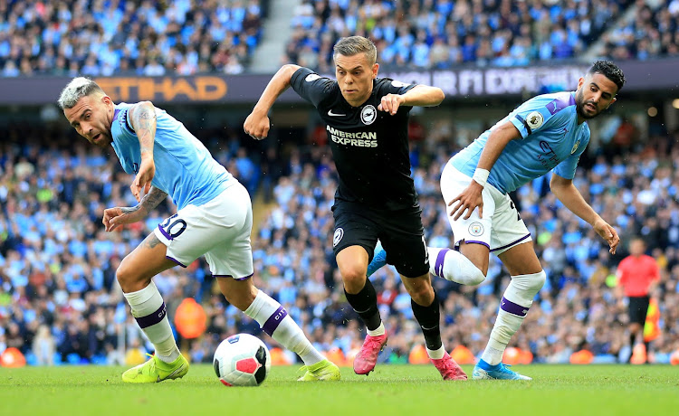 Brighton and Hove Albion's Leandro Trossard in action with Manchester City's Nicolas Otamendi and Riyad Mahrez