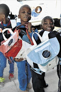 effective: 
      Pupils with bags made from plastic shopping  bags, which are solar-retro, charging during the day and used as lights at night to study and read Photo: Supplied