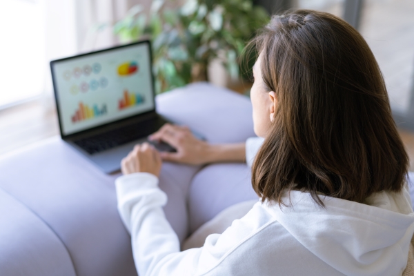 young-woman-home-sofa-white-hoodie-with-laptop-advisor-financial-business-analytics-woman-with-data-dashboard-graphs