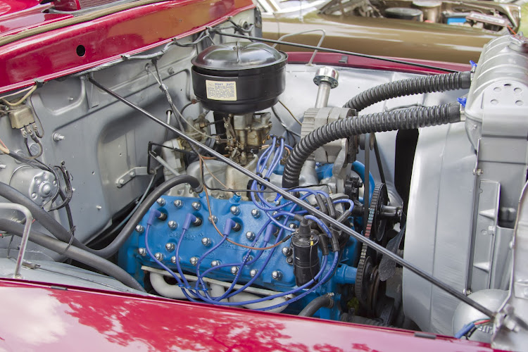 A V8 flathead engine inside a 1953 Ford F-100 pickup truck.