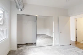 Bedroom featuring dark gray carpet, white walls, window, and closet