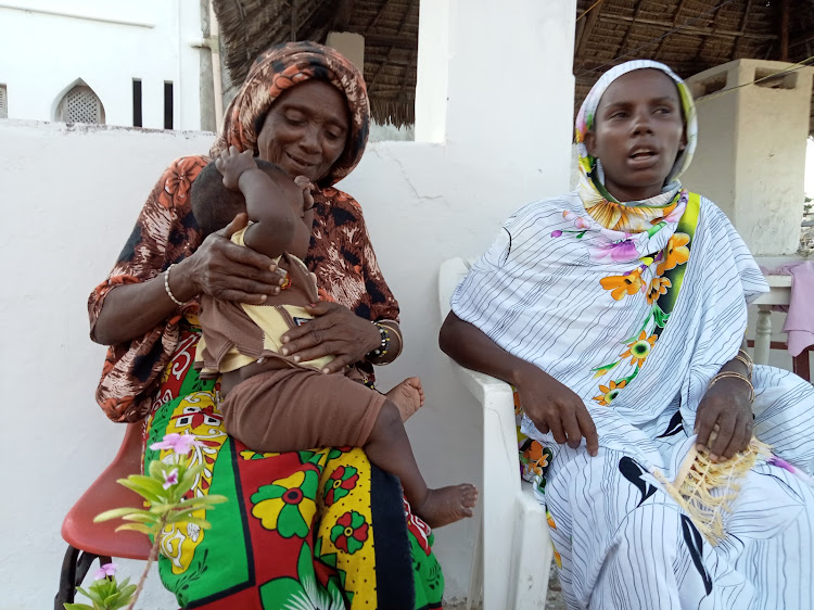 Fatma Shizo, a midwife from the Boni minority community in Lamu holds one of the babies she helped deliver.