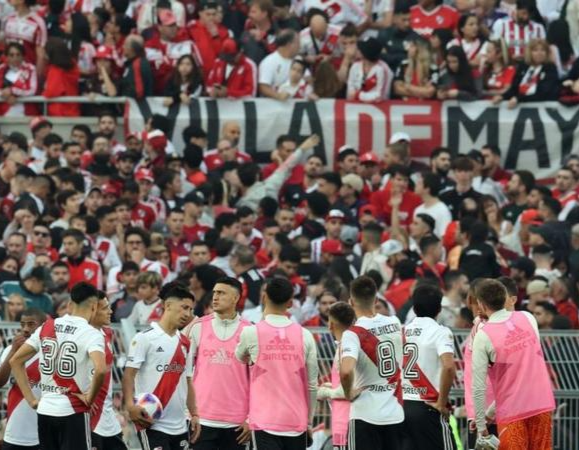 Players waited on the pitch for news after the referee initially suspended the match