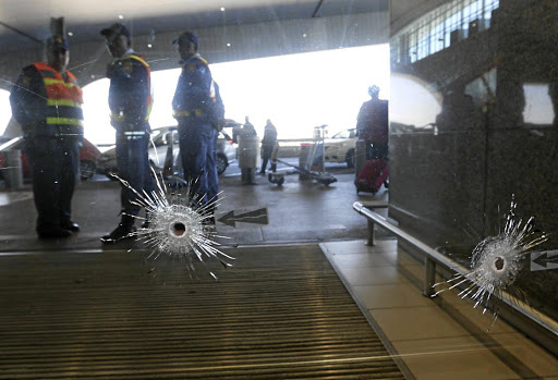 Bullet holes in the sliding doors at the departure terminal of Cape Town International Airport where a shooting took place.