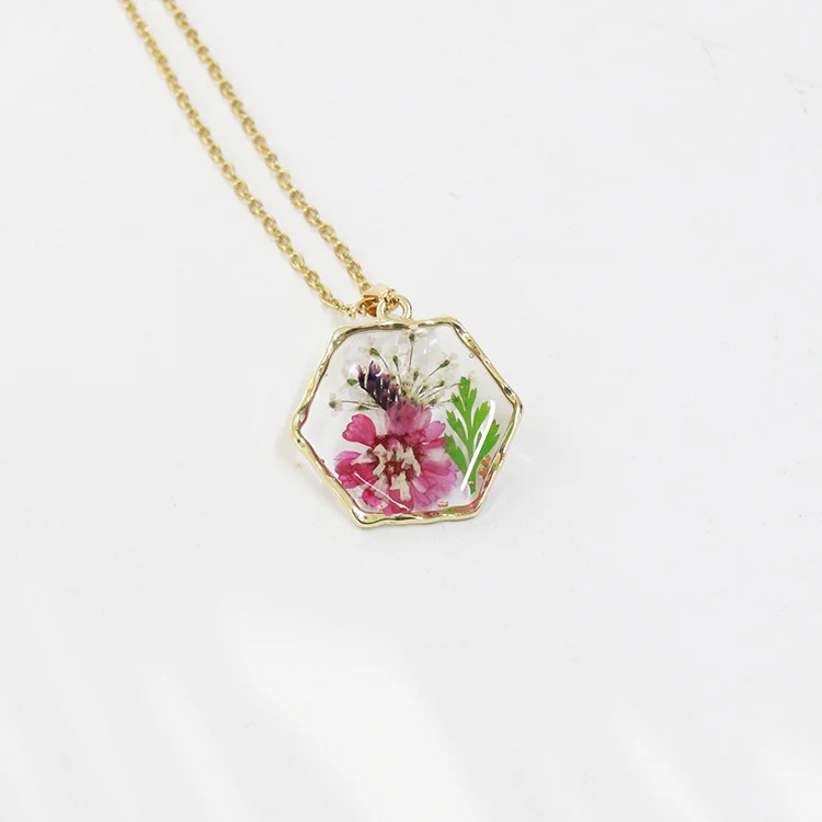 Polygon-Halskette mit konservierten Blüten und Trockenblumen. Einzigartiger, langlebiger und stilvoller Schmuck. Perfekt als Geschenk.