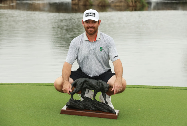 Louis Oosthuizen poses with the Alfred Dunhill Championship trophy on the extra day five of the rain-affected tournament at Leopard Creek Country Club in Malelane on Monday.