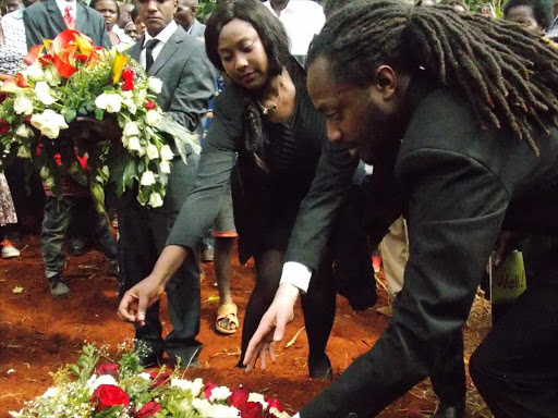 The Star Newspaper's Revise Editor Junias Mbogo's daughter Victoria Wetitu Hard and Son Victor lay a wreath of flowers on his grave during his burial at Manyatta Village in Embu North Sub-county on Saturday. He was buried by colleagues, politicians and people of all walks of life whom he interacted with very well.