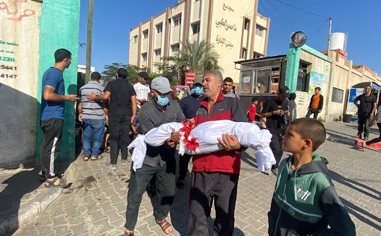 Palestinian Awad Abu Shamaleh carries the body of his nephew Elias, who, according to him, was injured in an Israeli airstrike and later died due to the lack of medicine, in Khan Younis, Gaza on October 26 2023. Picture: REUTERS/Arafat Barbakh