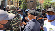 Politicians including the ANC's Tony Yengeni (pictured in beret),  former transport minister Joe Maswanganyi, Supra Mahumapelo and Carl Niehaus found themselves in the middle of a brawl between the police and supporters wanting to enter court, where the party's secretary-general Ace Magashule will be appearing on a charge of corruption.