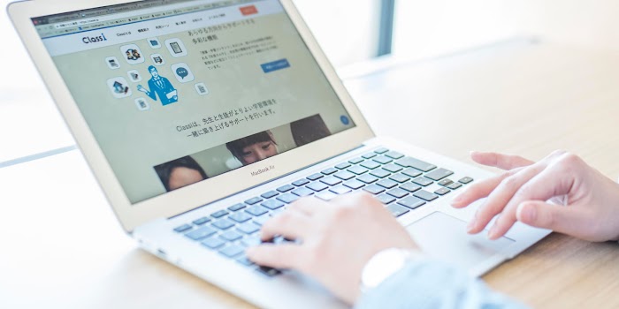 Person typing on laptop with Classi interface on screen