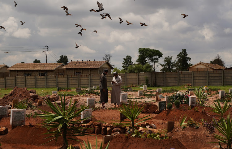 Mourners at the Lenasia cemetery visit the grave of a person who succumbed to Covid-19.