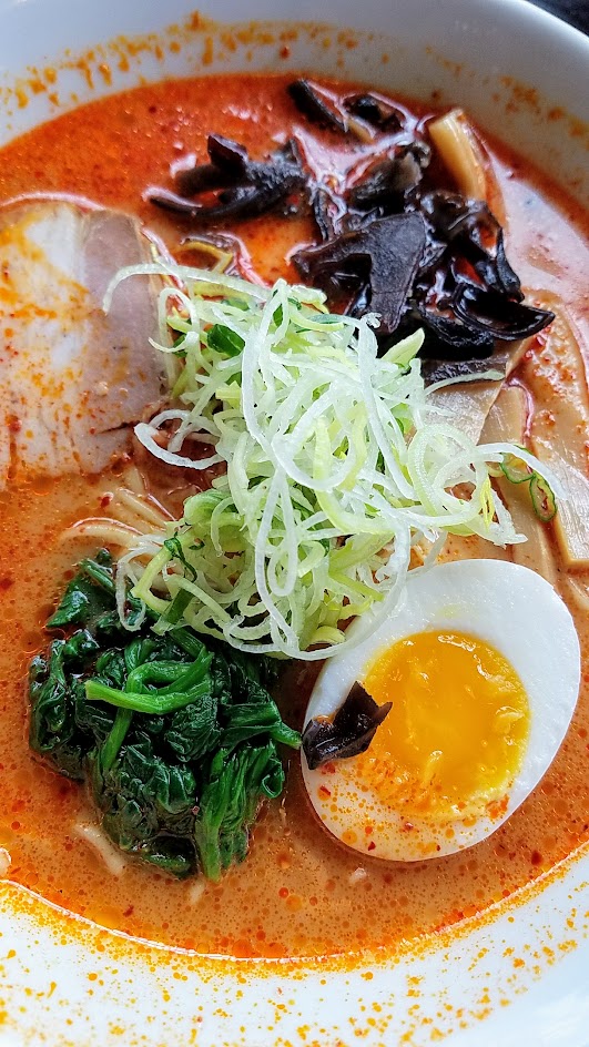 Marukin Ramen Tonkotsu Red Ramen with spicy pork bone broth, shoyu with toppings of spinach, kikurage, mushrooms, bamboo shoots, leeks, green onion, chashu pork, soft boiled egg