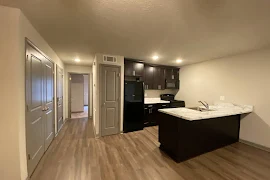 Living room area looking into kitchen and hallway to bedroom