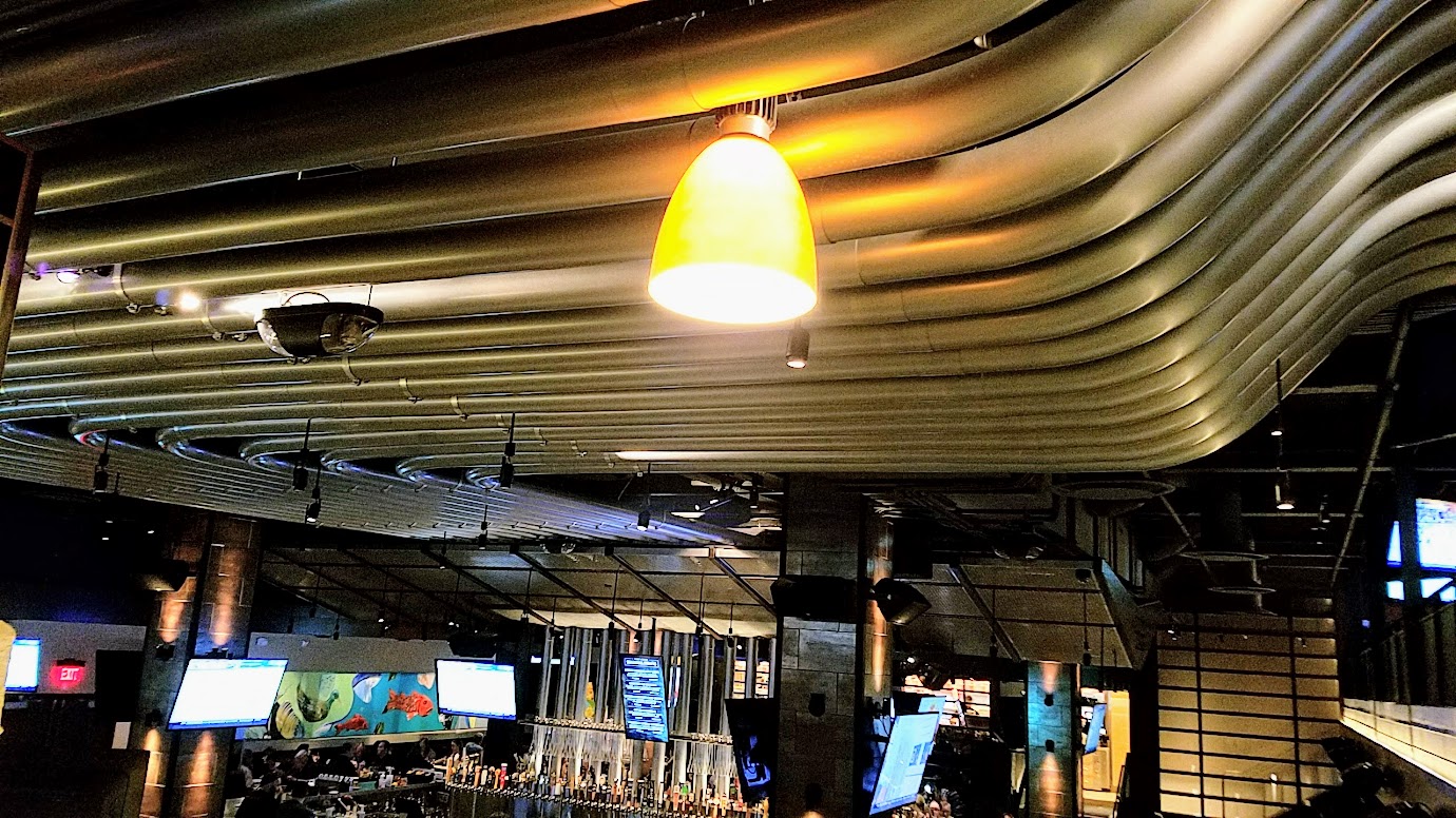 Yard House Portland offers 130 taps with a keg room holding over 5000 gallons of beer. When you are dining in the downstairs area, just look up: those metal cylinders carry six lines each, from the refrigerated keg room to the tap