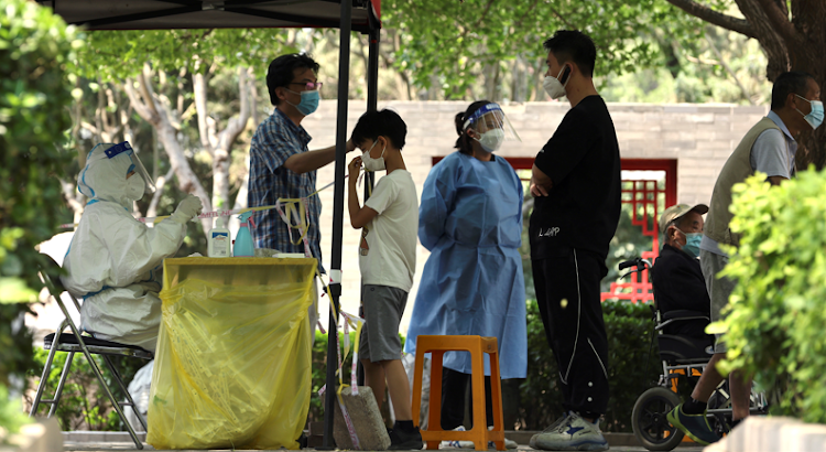 People line up for nucleic acid tests at a makeshift testing site, amid the coronavirus disease outbreak, in Beijing, China on May 23, 2022.