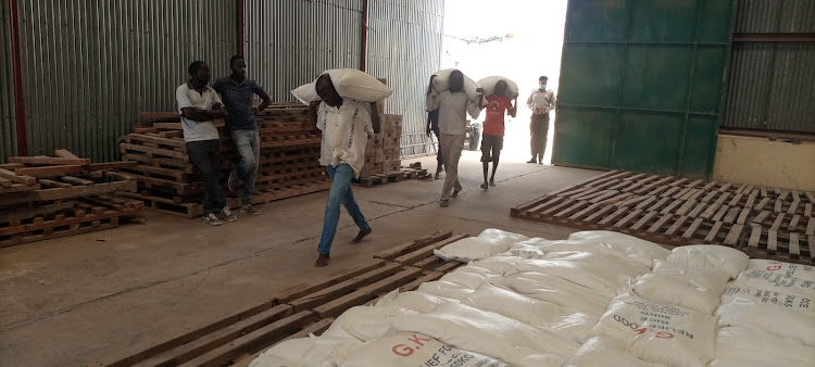 Casual laborers busy offloading relief food from tracks to store them at the Garissa cereals board store