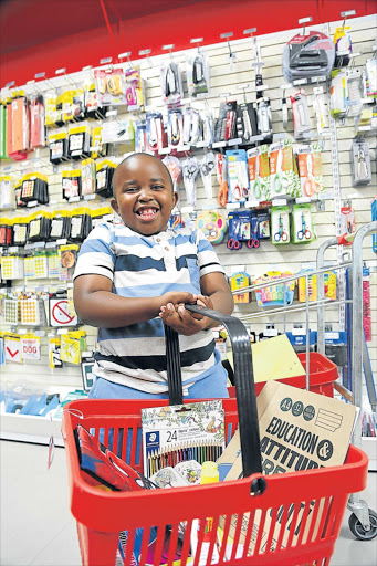 EDUCATIONAL TOOLS: Seven-year-old Teboho Rafuku is full of smiles while shopping for Grade 2 stationery with his family in Nahoon yesterday Picture: MARK ANDREWS