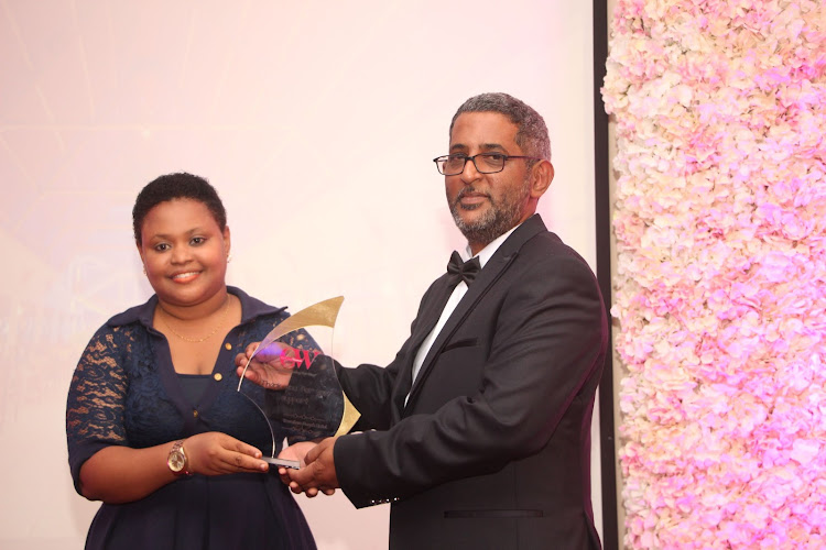 Travellers Beach Hotel guest relations manager Brigit Saru receives an award from Ridhwani Ahmed