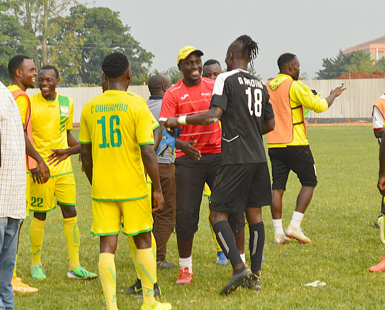 Kakamega Homeboyz coach Nicholas Muyoti (In red) congratulates his team after their match against Gor on Sunday